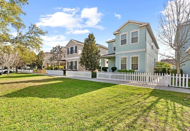 view of front of home with a fenced front yard, a front yard, and stucco siding