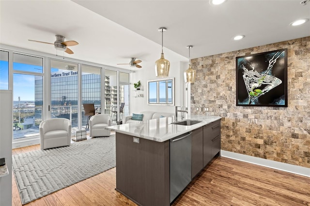 kitchen with a city view, a sink, open floor plan, light countertops, and stainless steel dishwasher