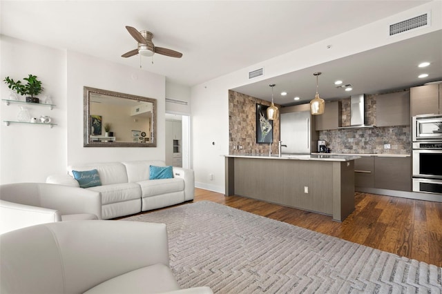 living area featuring a ceiling fan, visible vents, dark wood-type flooring, and recessed lighting