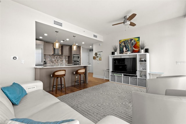 living area featuring ceiling fan, visible vents, dark wood-style flooring, and recessed lighting