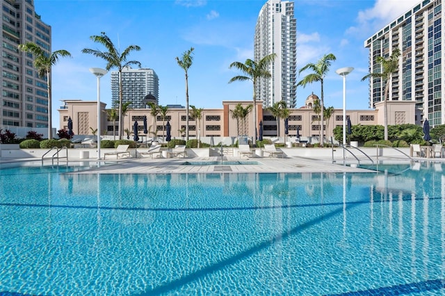 community pool with a view of city and a patio area