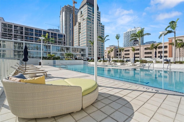 pool with a patio area and a city view