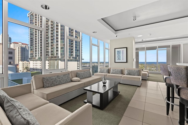 tiled living area featuring a wall of windows, a view of city, and a tray ceiling