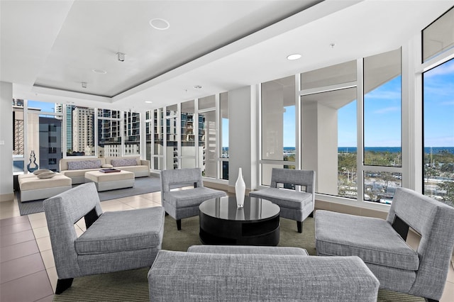 living room featuring light tile patterned flooring, a raised ceiling, and recessed lighting