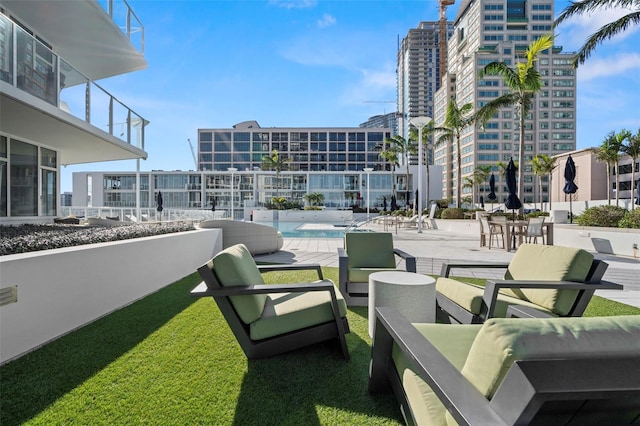 view of home's community with a view of city, a patio, and a swimming pool