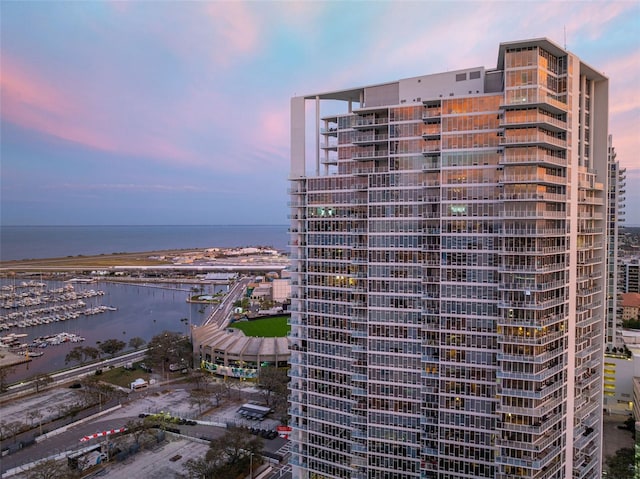 view of building exterior featuring a water view and a city view