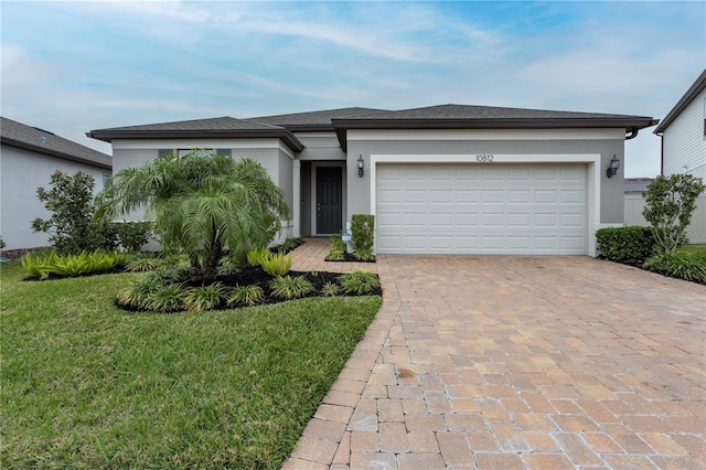 view of front of house with a garage, a front lawn, decorative driveway, and stucco siding