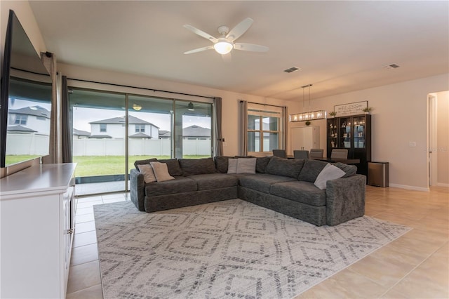 living room featuring visible vents, ceiling fan, baseboards, and light tile patterned floors