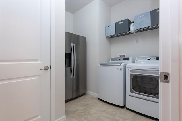 washroom featuring washer and dryer, laundry area, and baseboards