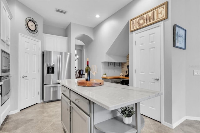 kitchen featuring visible vents, white cabinetry, light countertops, appliances with stainless steel finishes, and open shelves