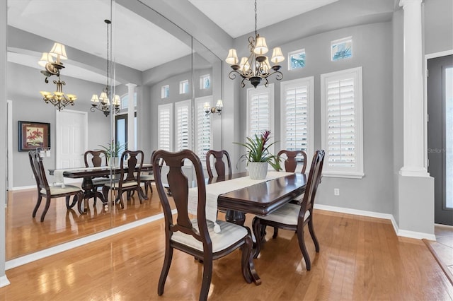 dining area featuring an inviting chandelier, light wood-style flooring, baseboards, and a wealth of natural light