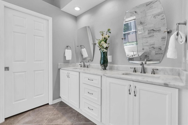 bathroom with a walk in shower, double vanity, a sink, and tile patterned floors