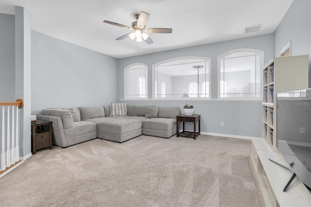 carpeted living room featuring baseboards, visible vents, and a ceiling fan