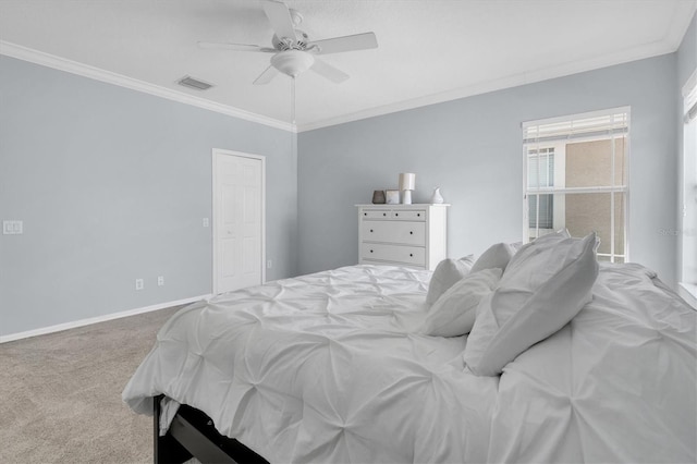 carpeted bedroom with visible vents, crown molding, baseboards, and ceiling fan