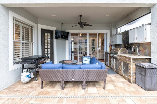 view of patio / terrace featuring outdoor lounge area, an outdoor kitchen, a ceiling fan, a grill, and a sink