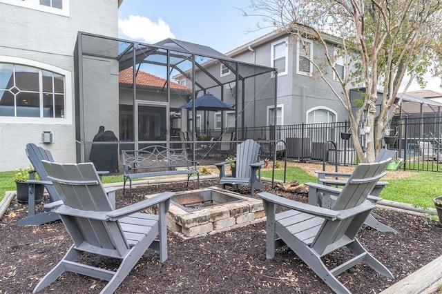 view of yard featuring glass enclosure, an outdoor fire pit, fence, and a patio