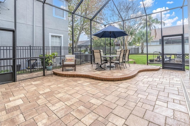 view of patio featuring glass enclosure and fence