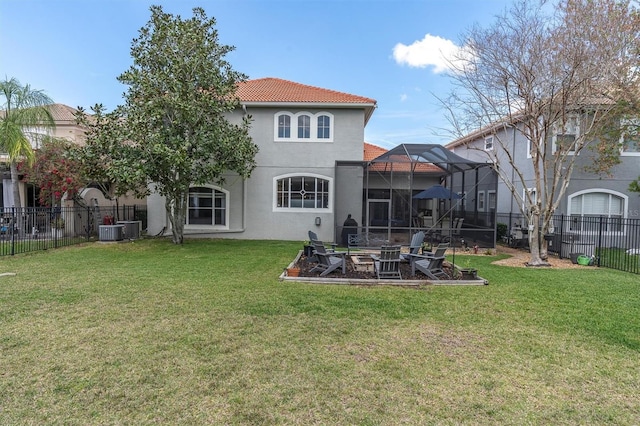 back of property featuring a yard, a lanai, a fenced backyard, and stucco siding