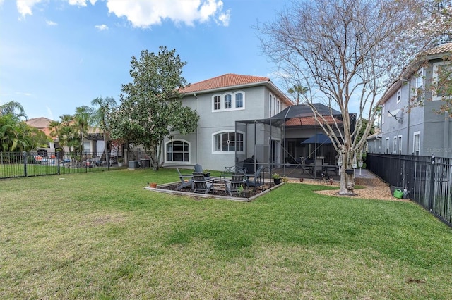 back of house featuring glass enclosure, a fenced backyard, a lawn, and stucco siding