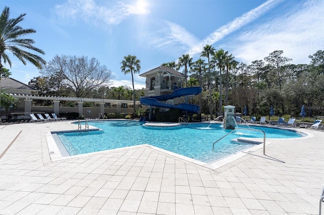 community pool with a water slide and a patio