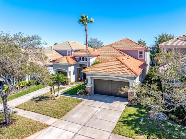 mediterranean / spanish home featuring a garage, a tile roof, driveway, stucco siding, and a front yard