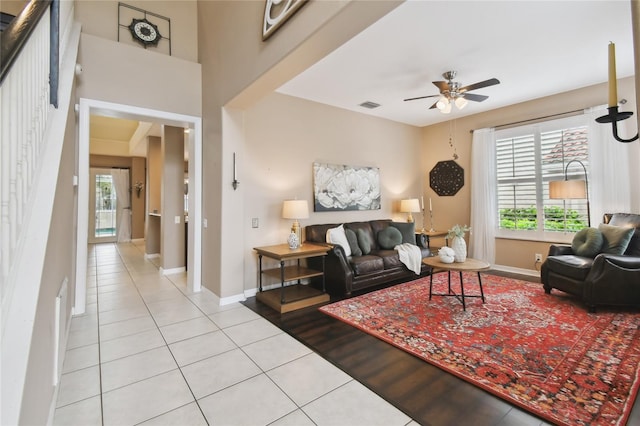 living room with a ceiling fan, light tile patterned floors, baseboards, and visible vents