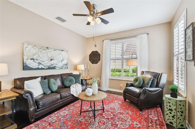 living room with visible vents, baseboards, a ceiling fan, and wood finished floors