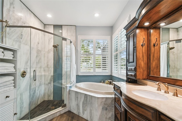 full bathroom featuring vanity, a garden tub, and a shower stall