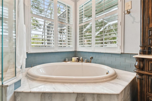 bathroom featuring a bath and a wealth of natural light