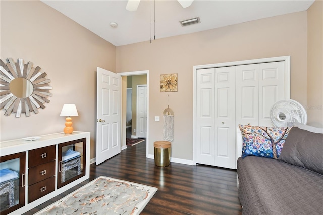 interior space featuring visible vents, dark wood-type flooring, baseboards, a closet, and a ceiling fan