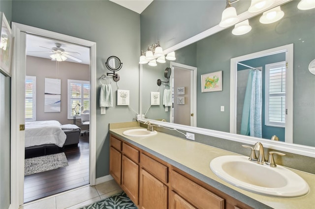 bathroom featuring tile patterned floors, double vanity, ensuite bathroom, and a sink