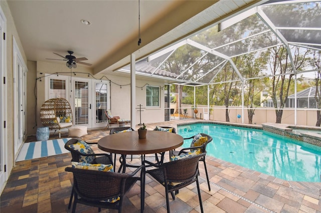 view of pool featuring a ceiling fan, a pool with connected hot tub, a patio, french doors, and glass enclosure