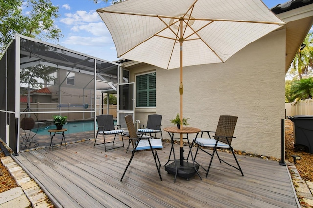 wooden terrace featuring an outdoor pool and a lanai