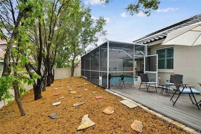 view of yard with an outdoor pool, a wooden deck, a lanai, and a fenced backyard