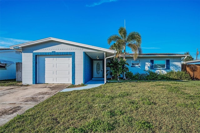 ranch-style house featuring a garage, a front yard, concrete block siding, and concrete driveway