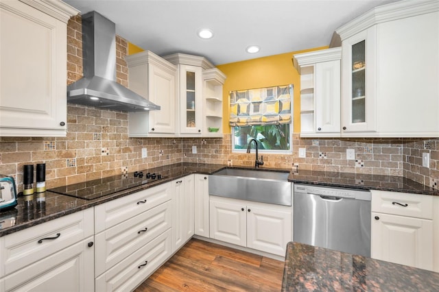 kitchen with white cabinets, wall chimney range hood, dishwasher, open shelves, and glass insert cabinets