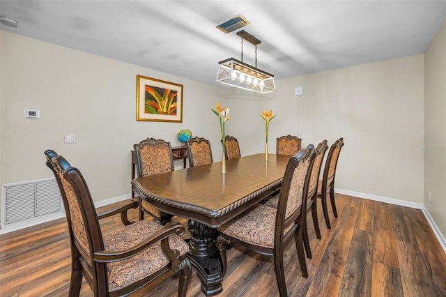 dining room with dark wood-type flooring, visible vents, and baseboards