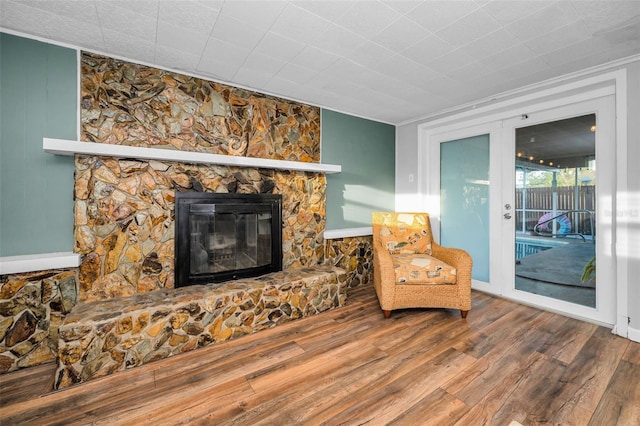 sitting room with a fireplace, wood finished floors, and french doors