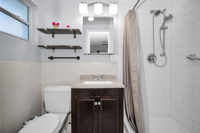 full bath with a tile shower, toilet, tile walls, and vanity