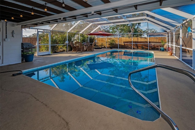 view of pool with a patio, a fenced backyard, glass enclosure, and a fenced in pool