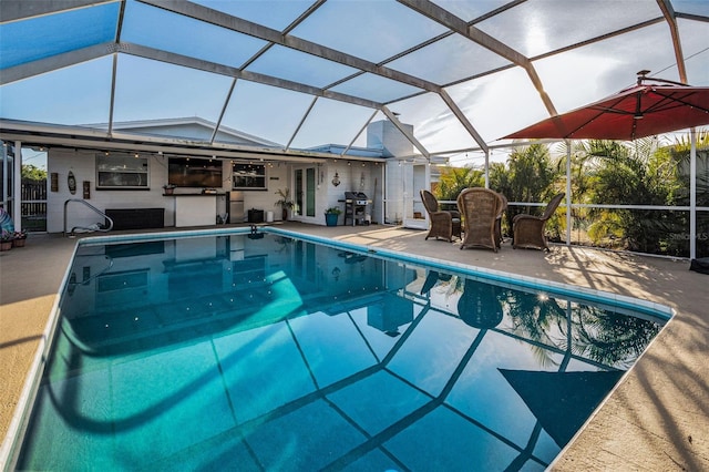 pool featuring exterior kitchen, a lanai, a patio area, and grilling area