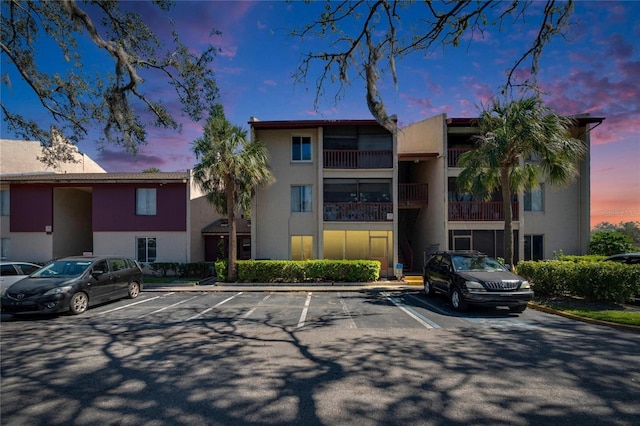 property at dusk with uncovered parking