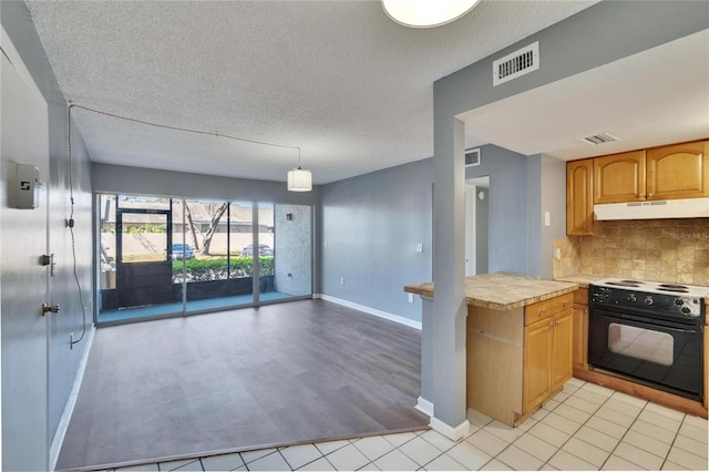 kitchen featuring tasteful backsplash, visible vents, light countertops, under cabinet range hood, and black range with electric cooktop