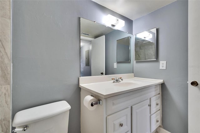 half bath featuring toilet, vanity, and visible vents