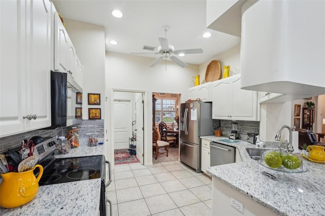 kitchen featuring light tile patterned floors, stainless steel appliances, visible vents, white cabinets, and light stone countertops