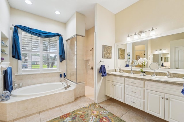 full bath featuring a garden tub, tile patterned flooring, walk in shower, and a sink