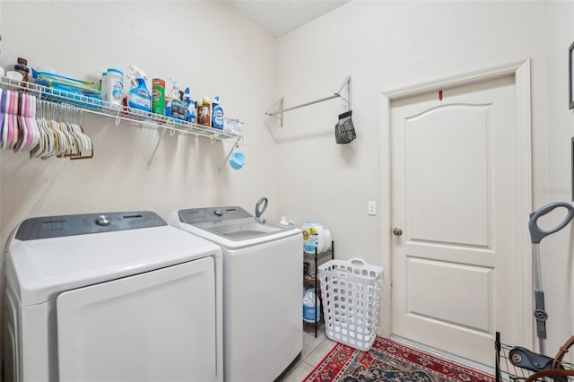 clothes washing area featuring washing machine and dryer, laundry area, and light tile patterned floors