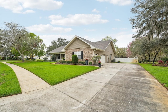 view of front of house featuring concrete driveway, stone siding, an attached garage, fence, and a front yard