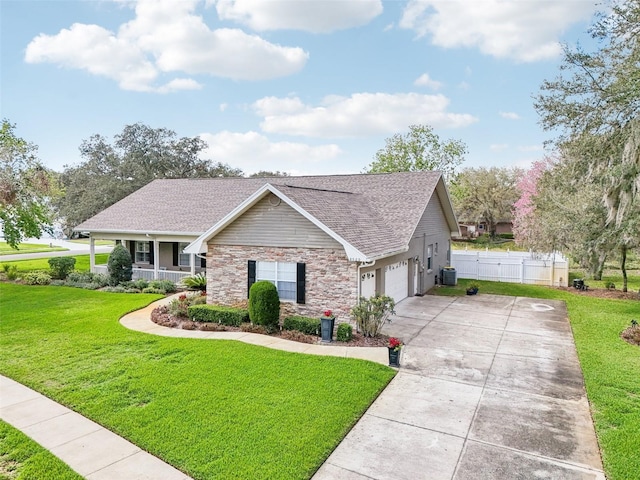 view of front of property with concrete driveway, stone siding, cooling unit, a porch, and a front yard