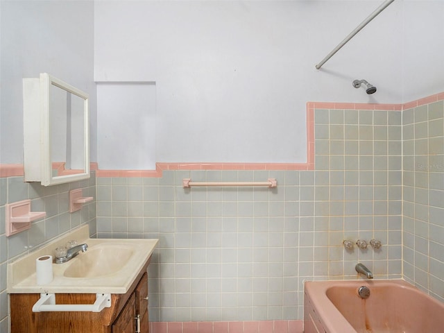 bathroom featuring a wainscoted wall, bathtub / shower combination, tile walls, and vanity